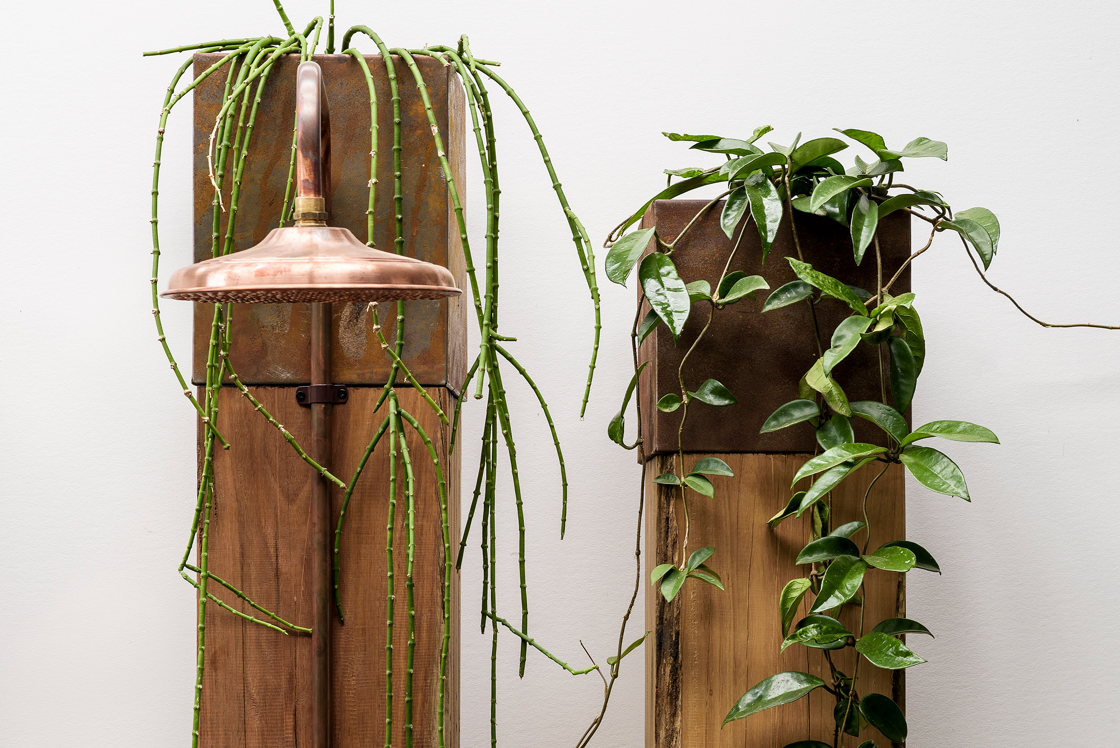 Bespoke recycled timber pillar outdoor showers with copper planter boxes
