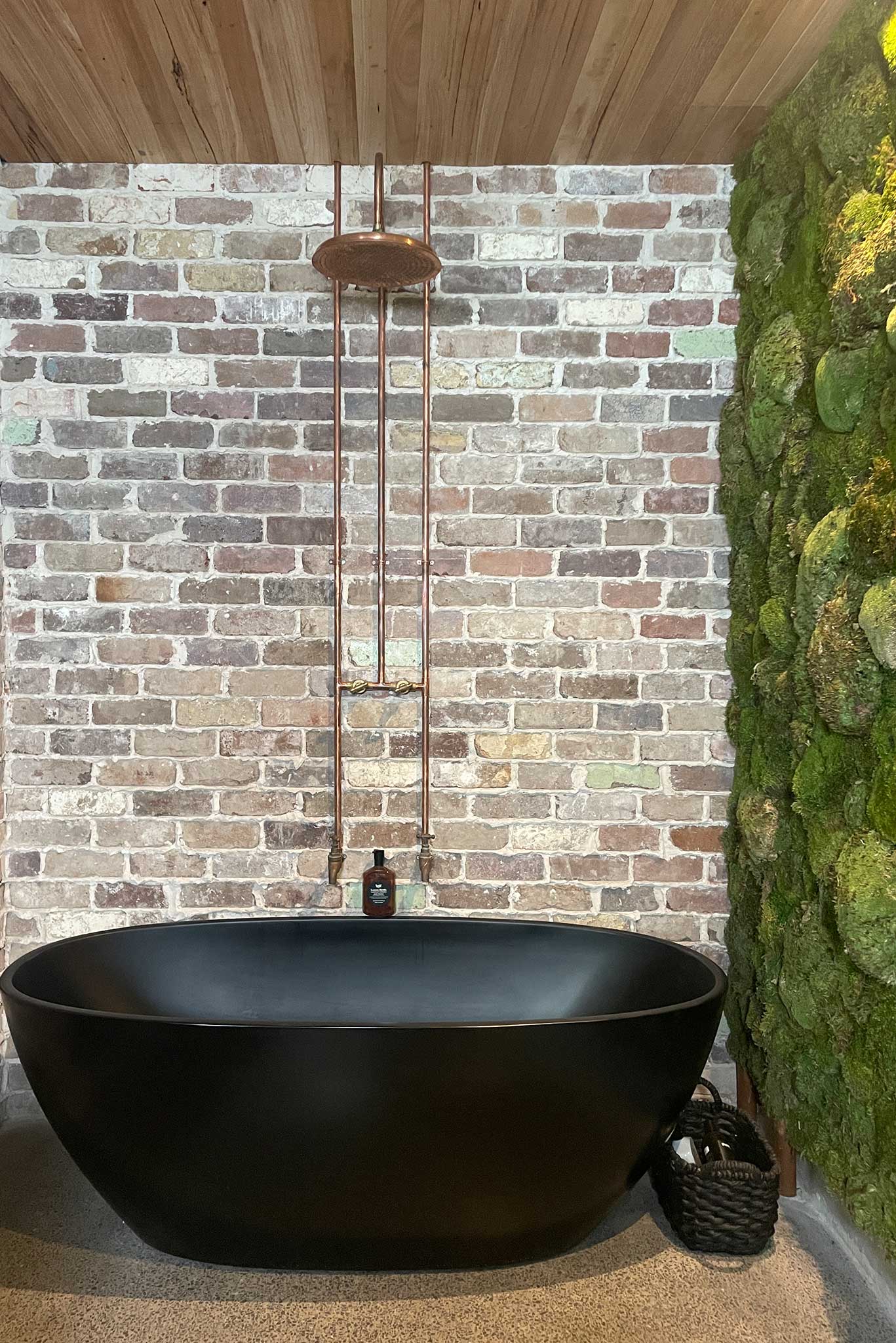 Interior Fitout + Moss Wall Central Coast - Project "Moss Wash" - Moss wall, exposed brick wall and freestanding black bath tub with copper piping