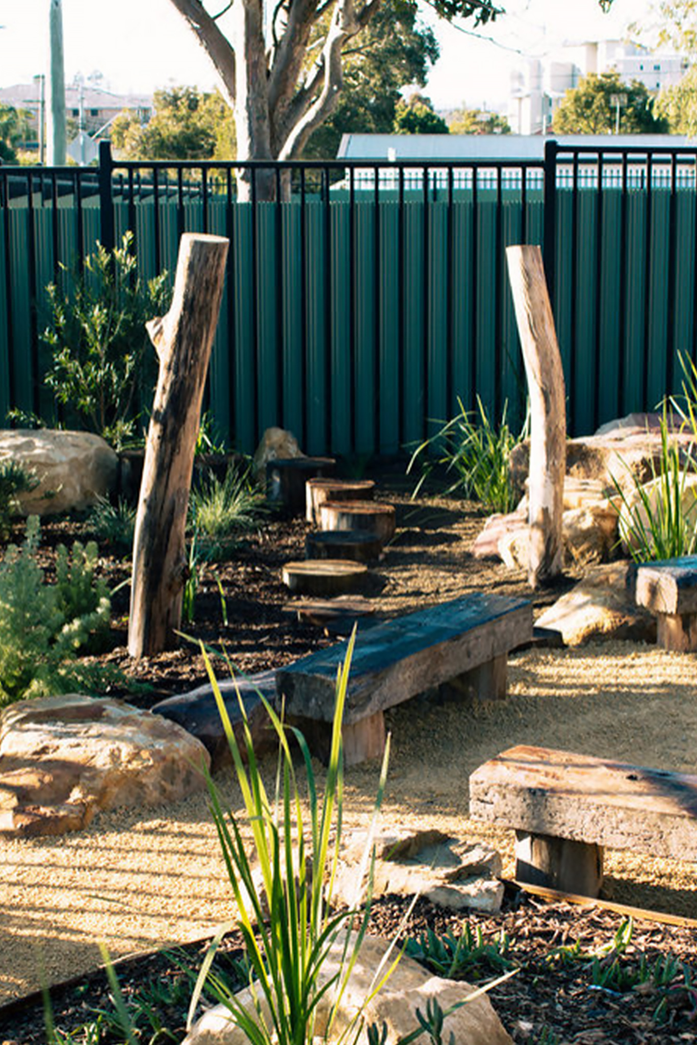 Nature playground with stepping logs, decomposed granite pathway and native planting