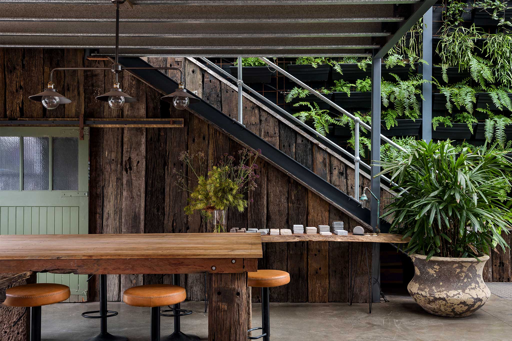 Commercial Interior Fitout Central Coast - Project "MBS Warehouse Jungle" - recycled railway sleeper-clad staircase with meeting table in foreground